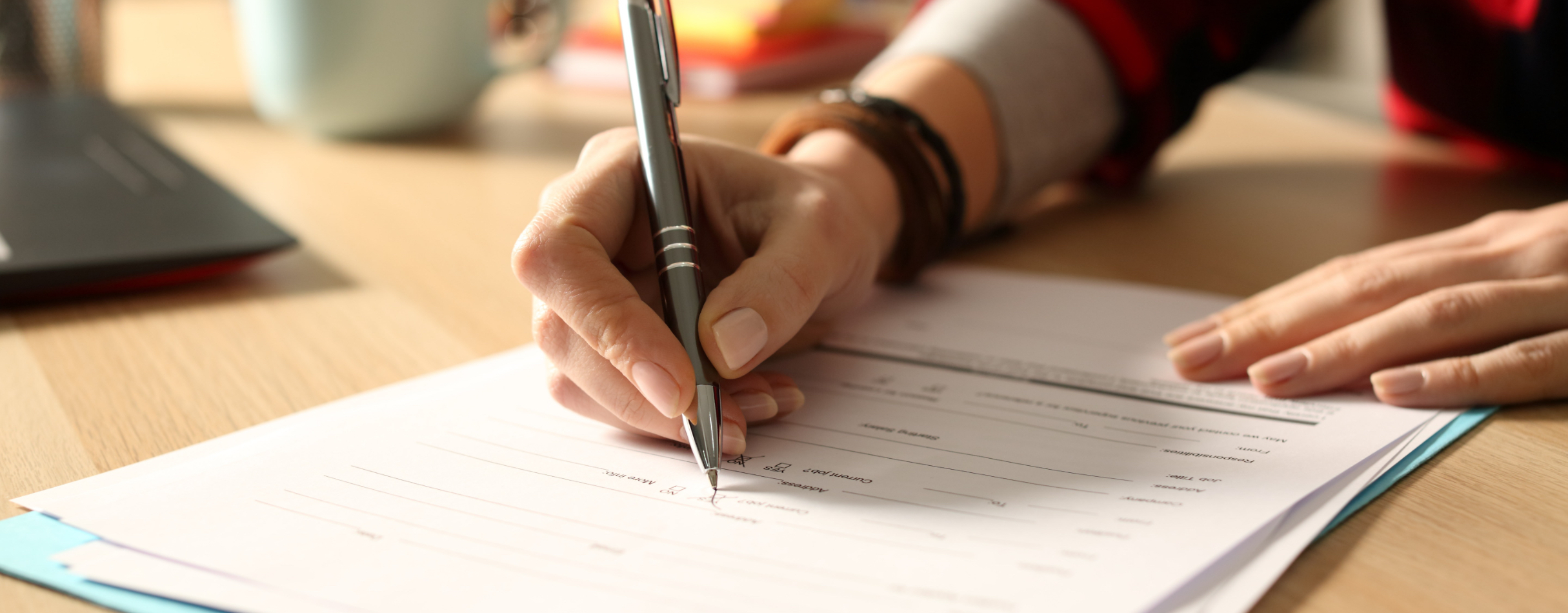 Close-up on a woman's hands signing a form