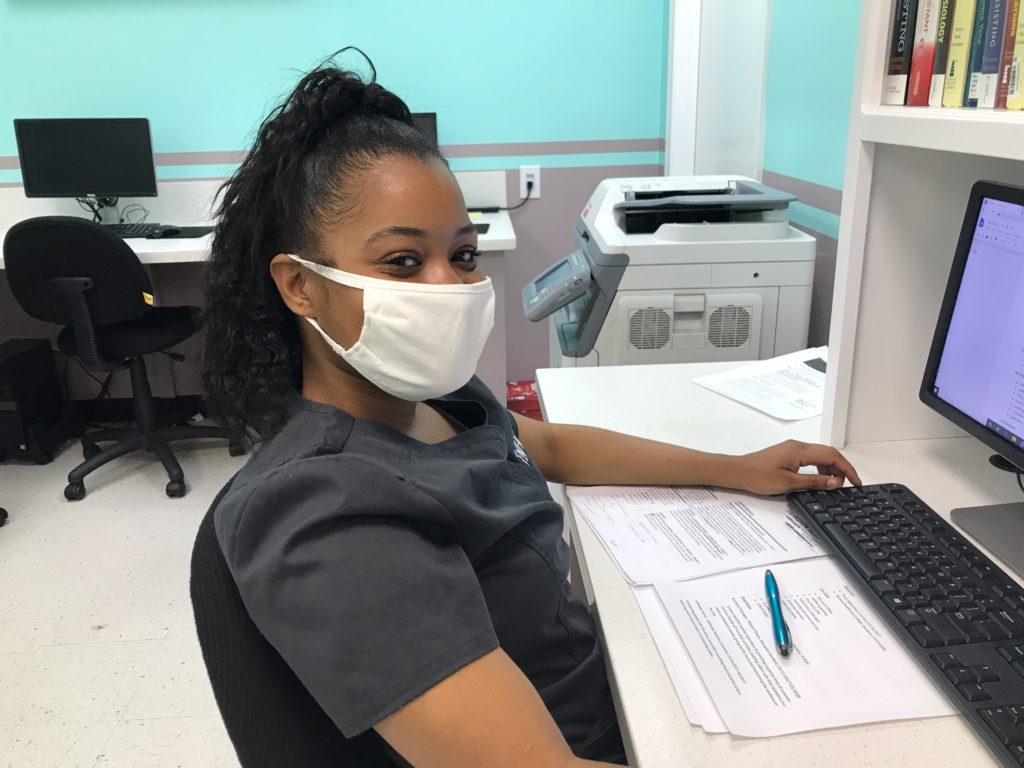Medical Assistant student sitting in front of her computer