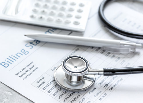 billing statement for for medical service in doctor's office on stone desk background